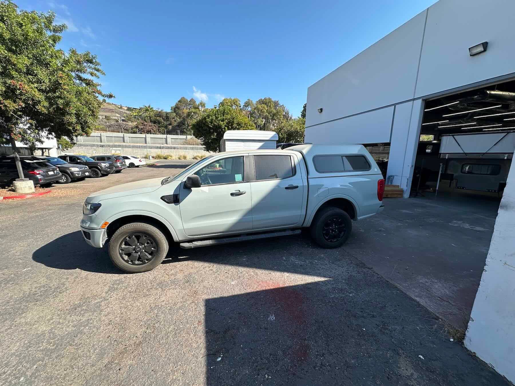 Grey Ford Ranger parked in a lot with a building in the background