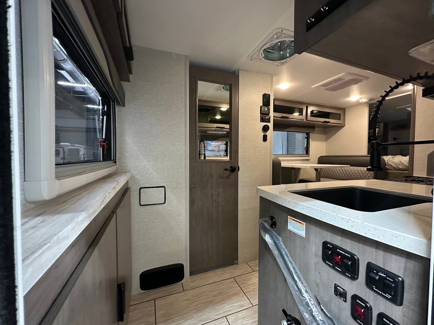 Interior of Lance 1191 with kitchenette, bathroom door and storage compartments.
