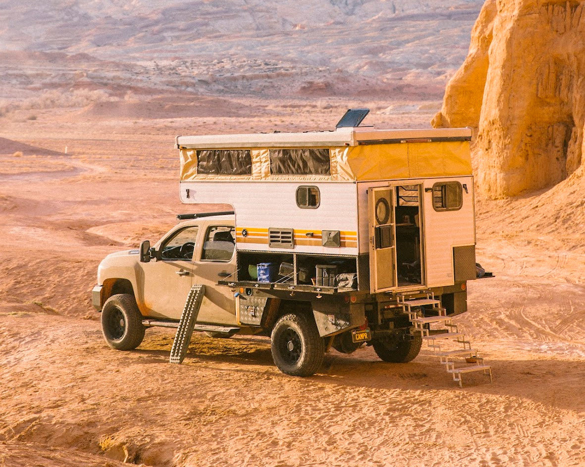 Truck with slide-in pop-up camper that TCG has worked on against desert background