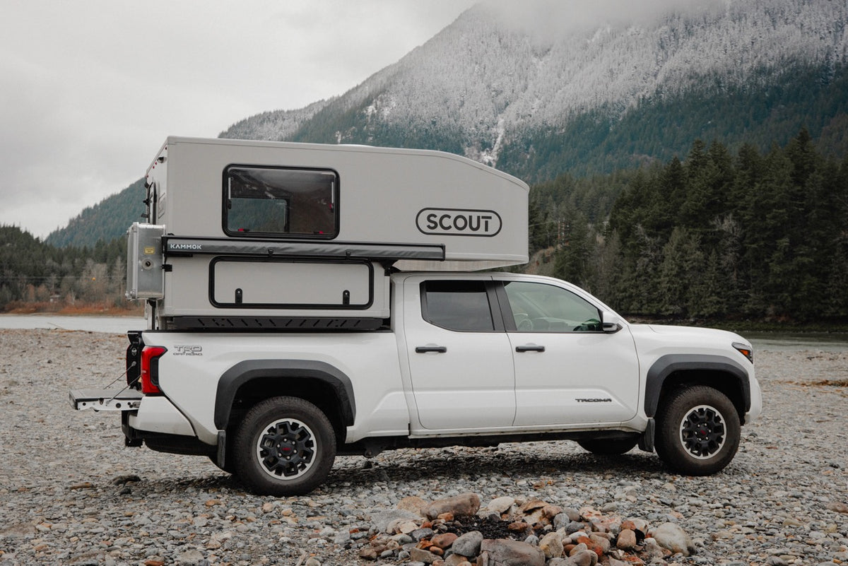 Hard side truck camper parked in a forest