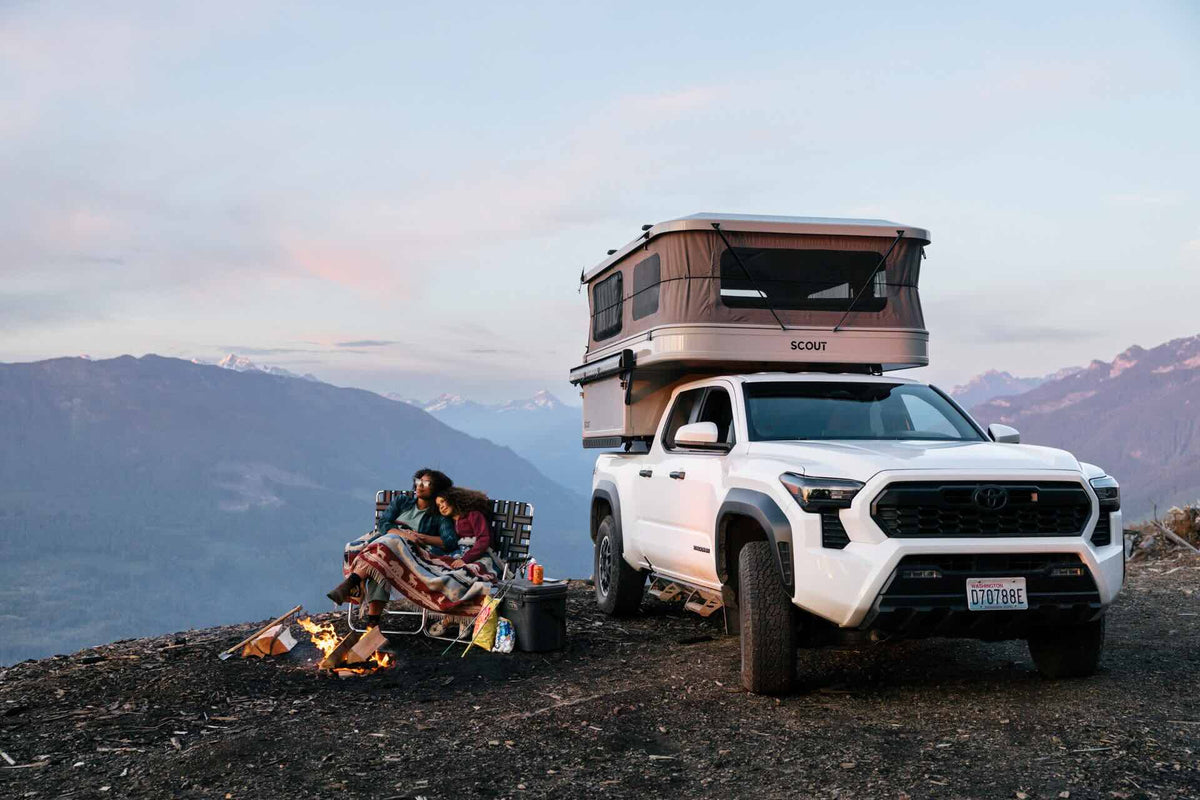 Pop-up truck camper with the roof raised at an alpine campsite