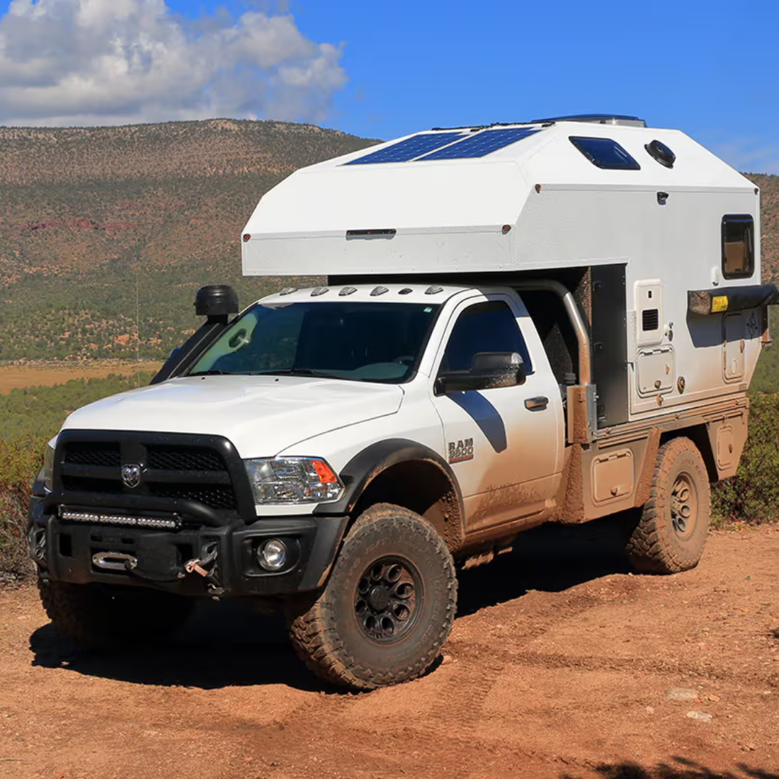 Flatbed AT Overland truck camper on a heavy duty pickup on a dirt road