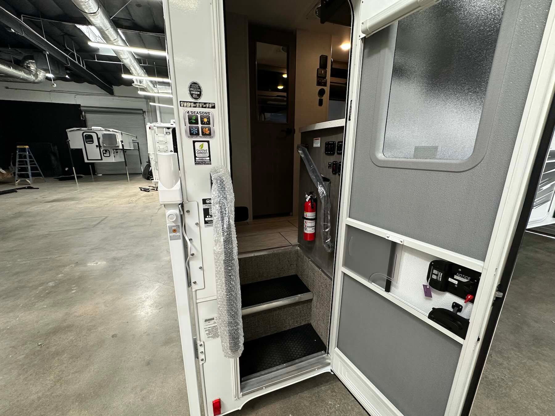 Interior of Lance 1191 truck camper with open door showing storage compartments