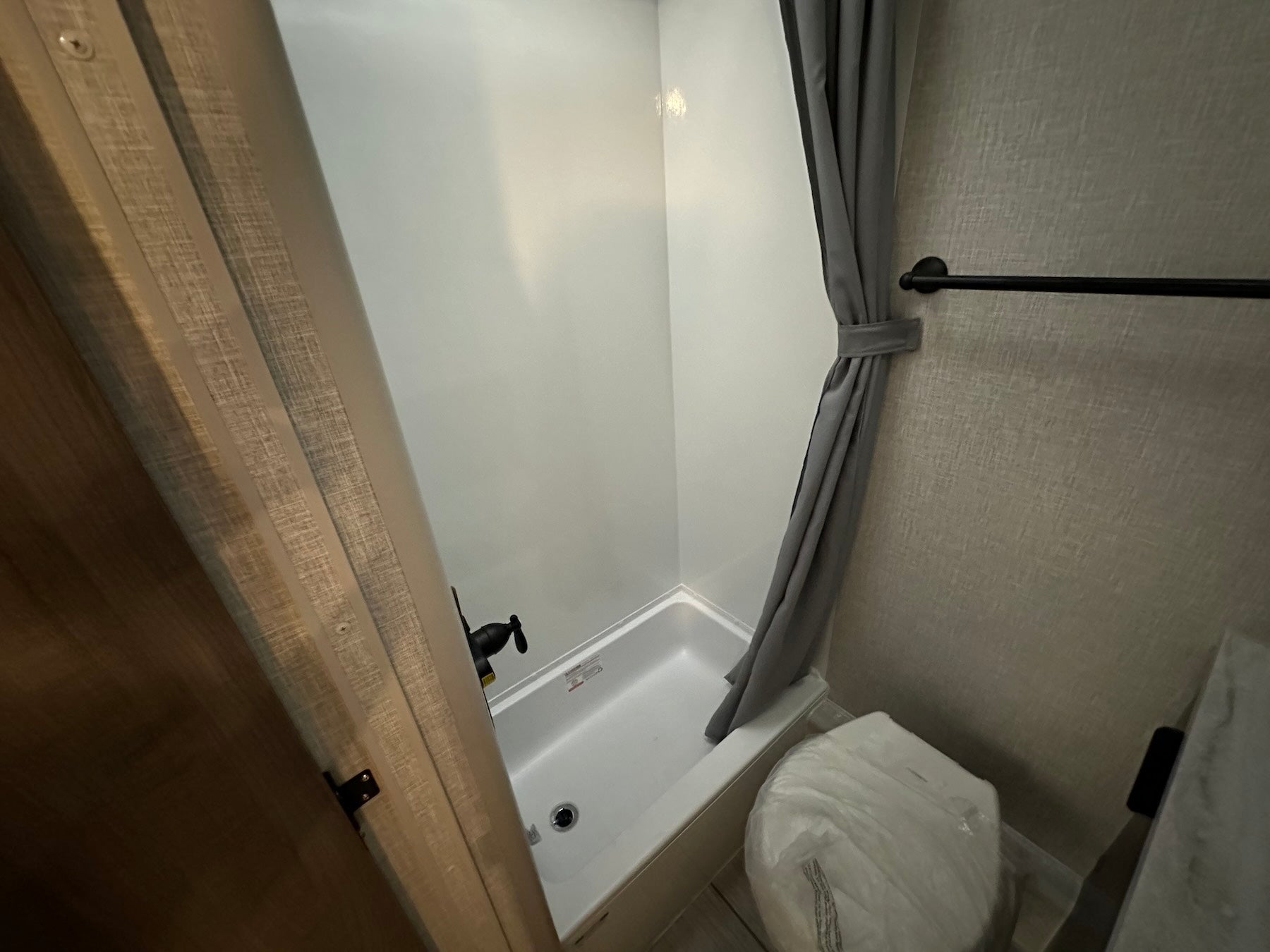 Interior view of Lance 1191 truck camper bathroom showing shower pan and toilet