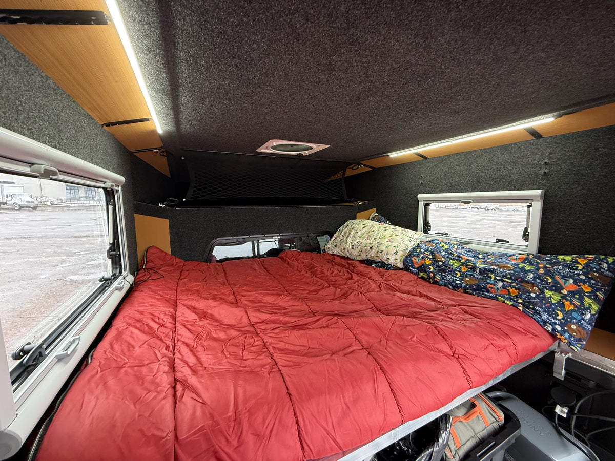 East-west cabover bed in an OVRLND camper topper